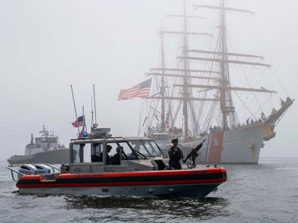 A patrol vessel helps escort the Coast Guard cutter Eagle in the Port of Los Angeles as it