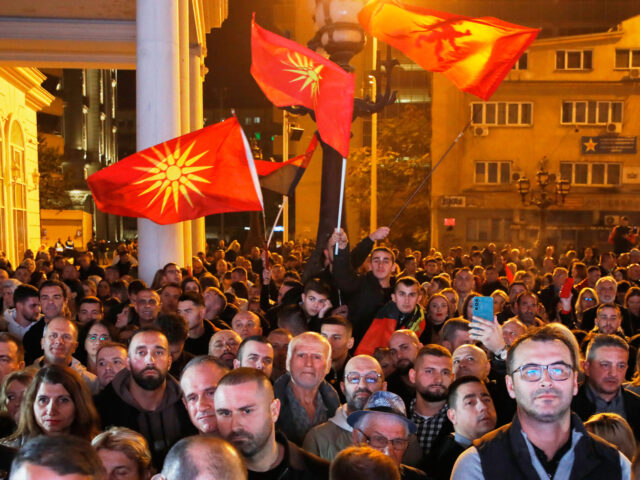 Supporters of the conservative VMRO-DPMNE party wave party flags and the old national flag