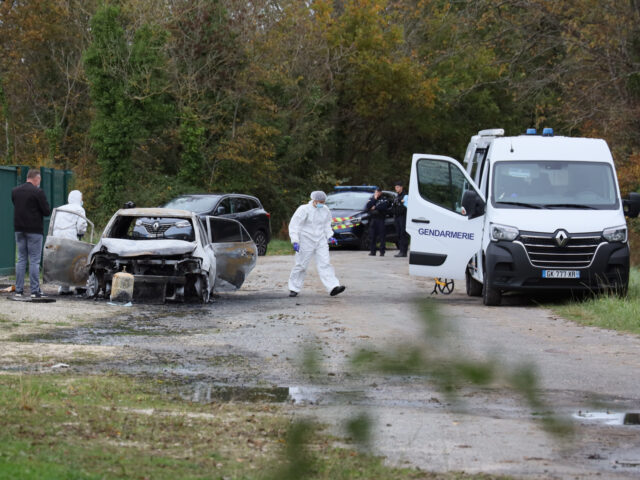 Investigators inspect the burned car after a motorist deliberately rammed pedestrians and