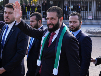 Syria's President Ahmed al-Sharaa waves as he greets supporters outside of the White House