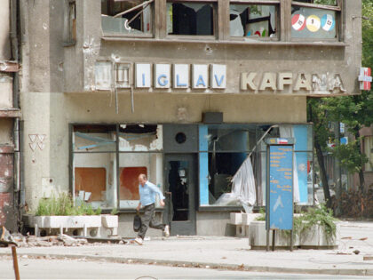 A Bosnian man runs in a Sarajevo street where many civilians have been hit by sniper fire.