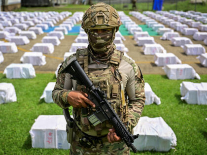 A Panamanian National Aeronaval Service officer guards 12 tons of cocaine divided into hun