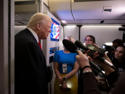 President Donald Trump speaks to the press aboard Air Force One after a trip to Florida on