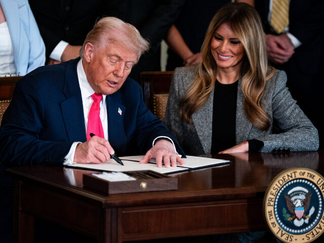 US First Lady Melania Trump, right, watches as President Donald Trump signs an executive o