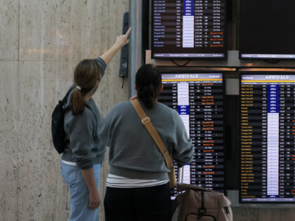 Los Angeles, CA - October 26: Travelers look at the flight information display system at L