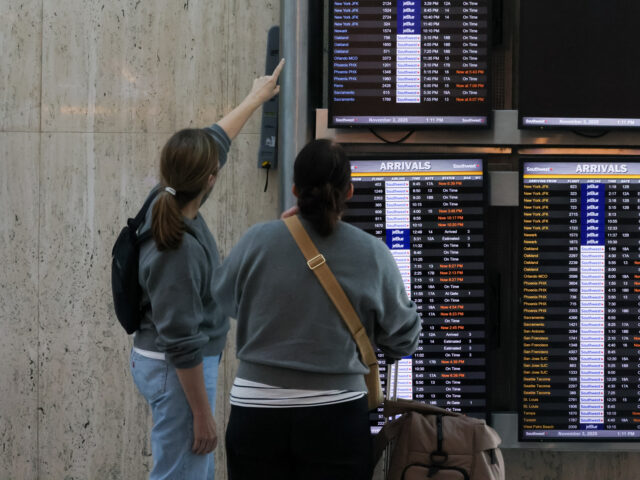 Los Angeles, CA - October 26: Travelers look at the flight information display system at L