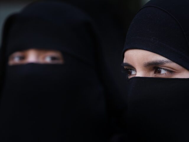 LONDON, ENGLAND - APRIL 11: Two women wearing Islamic niqab veils stand outside the French