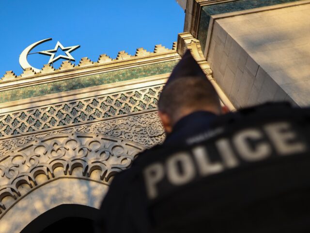 A French police officer stands guard in front of the entrance of the Grande Mosquee de Par