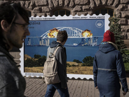 KYIV, UKRAINE - OCTOBER 12: People take photos in front of an image of a stamp showing exp