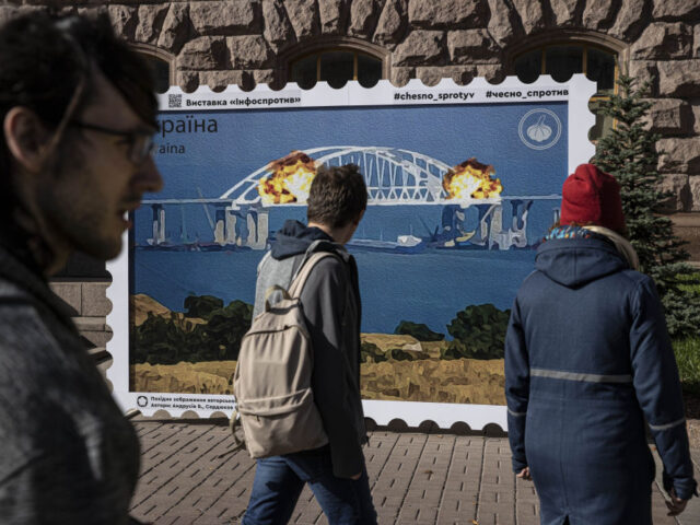 KYIV, UKRAINE - OCTOBER 12: People take photos in front of an image of a stamp showing exp