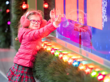 NEW YORK, NEW YORK - NOVEMBER 23: A child visits the newly unveiled holiday windows outsid