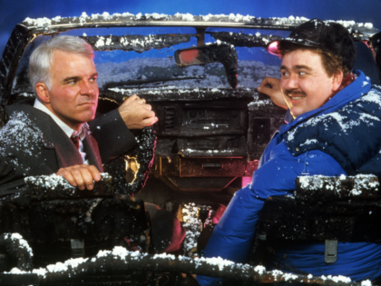Steve Martin and John Candy sit in a destroyed car in a scene from the film 'Planes, Train