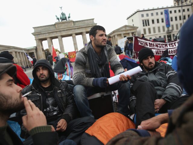BERLIN, GERMANY - OCTOBER 17: Refugees from Iraq, Iran and Afghanistan keep warm on the 8t