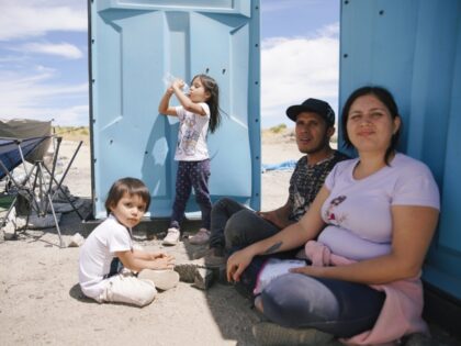 JACUMBA HOT SPRINGS, CALIFORNIA - JUNE 9: Migrants sit as they wait to cross into the US f