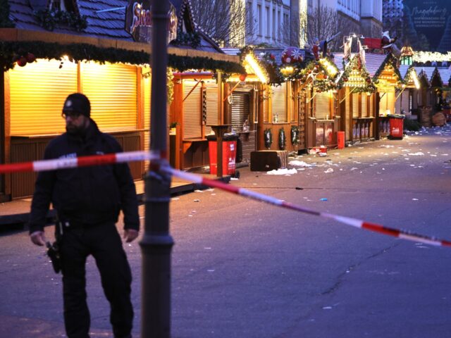 MAGDEBURG, GERMANY - DECEMBER 21: A policeman walks through the shuttered Christmas market