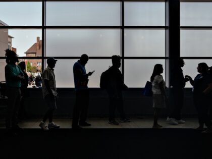Job seekers wait in line to enter an auditorium for a job fair hosted by the Cook County g