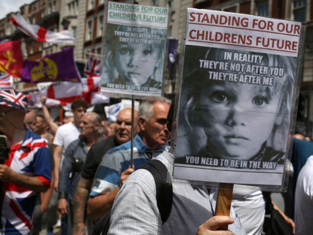 LONDON, ENGLAND - JUNE 28: Supporters of Tommy Robinson hold signs as they march across Lo