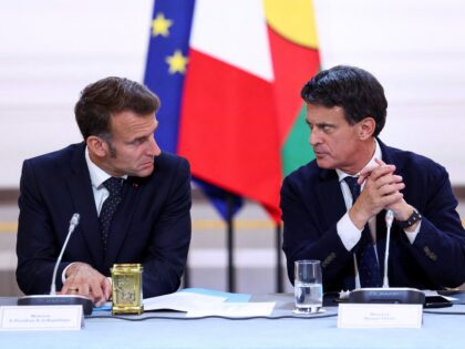 French President Emmanuel Macron (L) and France's Minister of Overseas Manuel Valls (R) ta