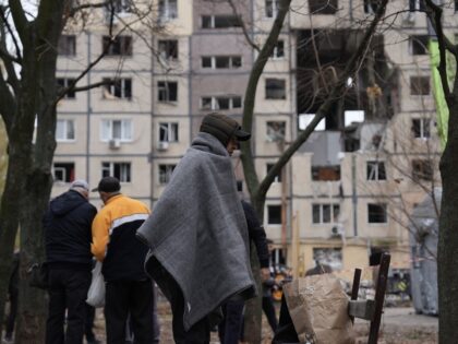 DNIPRO, UKRAINE - NOVEMBER 8: Residents wait in a yard while rescuers clear rubble in a hi