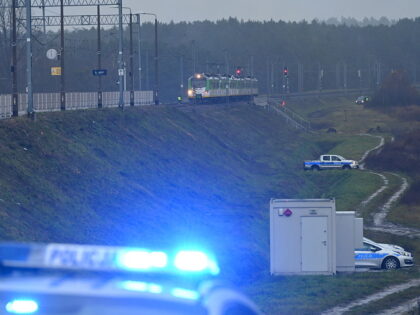 Police investigate at the scene of a damaged section of railway tracks on the Deblin-Warsa
