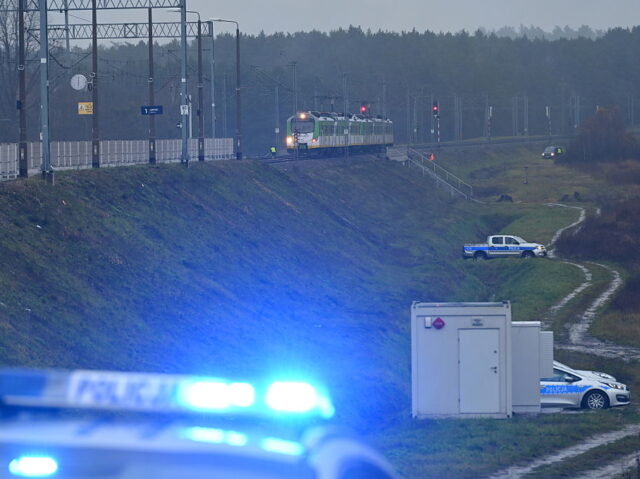 Police investigate at the scene of a damaged section of railway tracks on the Deblin-Warsa