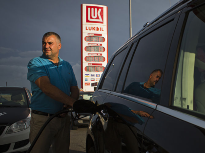 A customer refuels a vehicle using a fuel pump at an OAO Lukoil gas station in Prague, Cze