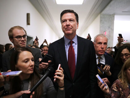 Former Federal Bureau of Investigation Director James Comey is surrounded by reporters aft