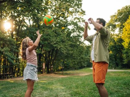 An active family is spending sports day in nature. A sportive father and daughter are stan