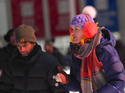 People cover themselves with scarf and hat to avoid cold weather as snowfall is expected w