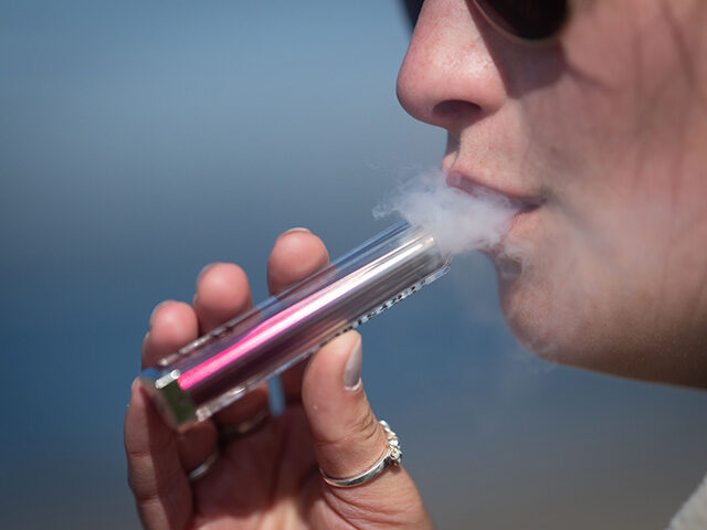 A woman poses for a photograph holding a single-use vape on April 5, 2025 in Cardiff, Unit