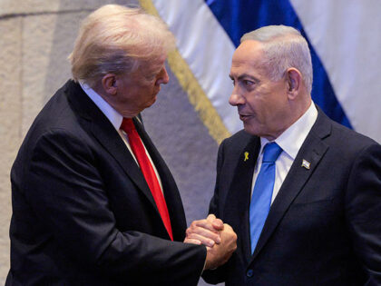 US President Donald Trump (L) holds hands and speaks with Israeli Prime Minister Benjamin