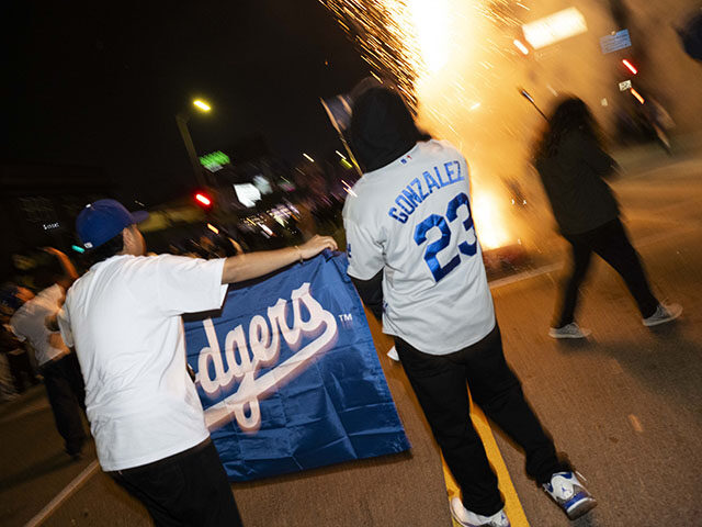 GettyImages2244113579 A Los Angeles Dodgers fan lights fireworks on the street during celebrations in Echo Park