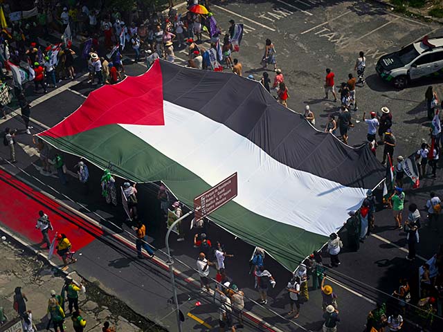 Ativistas carregam uma enorme bandeira palestina durante o chamado 