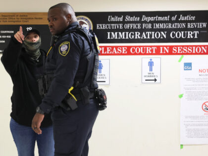 Homeland Security officers speak with a federal agent as they patrol the halls of immigrat