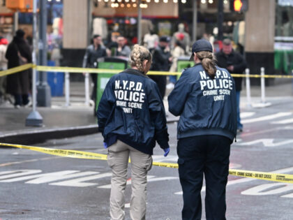Members of the NYPD Crime Scene Unit investigate the scene and canvass the area while look