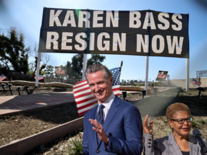 A view of a 7-foot tall sign calling on Los Angeles Mayor Bass to resign at an empty lot w