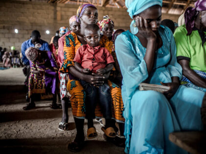 A Christian Adara boy prays along with his mother while attending the Sunday's servic