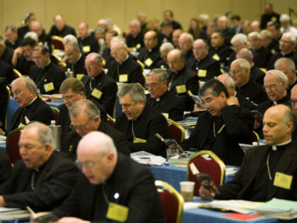 Bishops from around the US participate in an opening prayer during the fall meetings of th