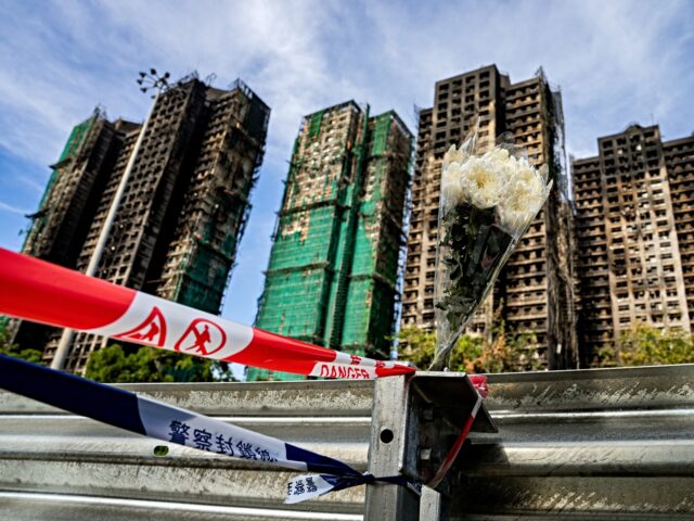 Floral tributes for victims of the fire at Wang Fuk Court residential estate left on a bar