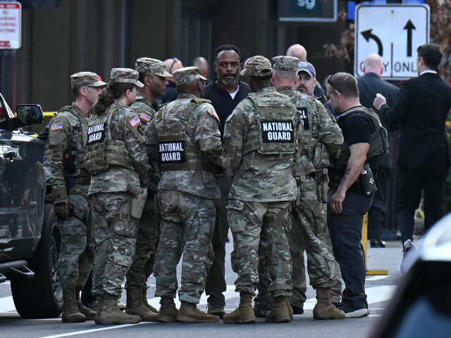 National Guard soldiers huddle around law enforcement officers while receiving information