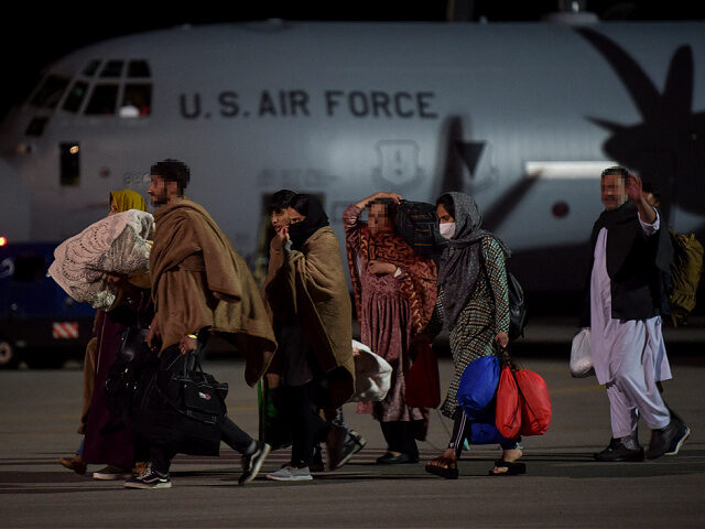 aug2021-Afghan-refugees-fleeing-Kabul-u-s-getty TOPSHOT - Afghan refugees, fleeing the Afghan capital Kabul, exit an US air force plane up