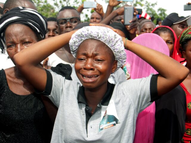 Relatives cry as they mourn during a funeral service for 17 worshippers and two priests, w