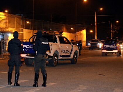 Police officers stand guard at the entrance of the prison after an armed riot that left fo