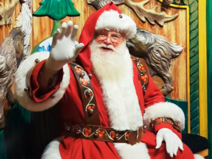 A man dressed as Santa Claus sitting on a bench