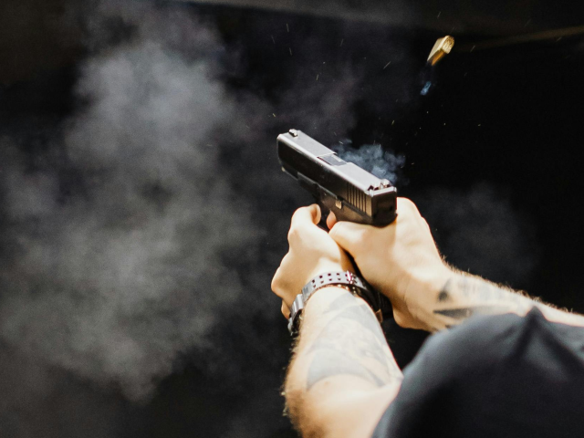 Man in Black Crew Neck T-shirt Firing a Gun