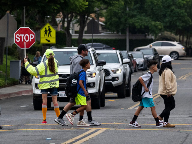 schoolchildren at crosswalk August 13: Students and parents head to the first day of class at Trabuco Mesa Elementary