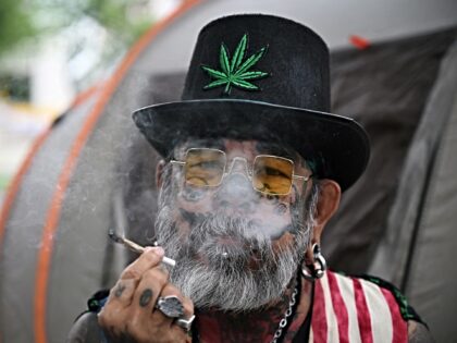 A pro-cannabis activist smokes a joint at a protest against the Thai government's proposal