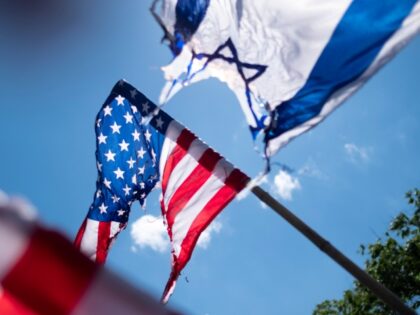 Iranian protesters (not pictured) wave a burnt Israeli flag and burnt U.S. flags during a