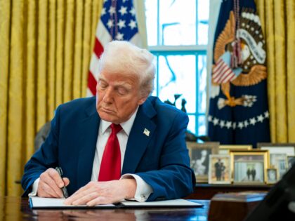 US President Donald Trump signs an executive order in the Oval Office of the White House i