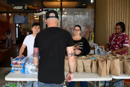 Eric Dunham (Center) is one of several Houston residents receiving free lunch bags at a re